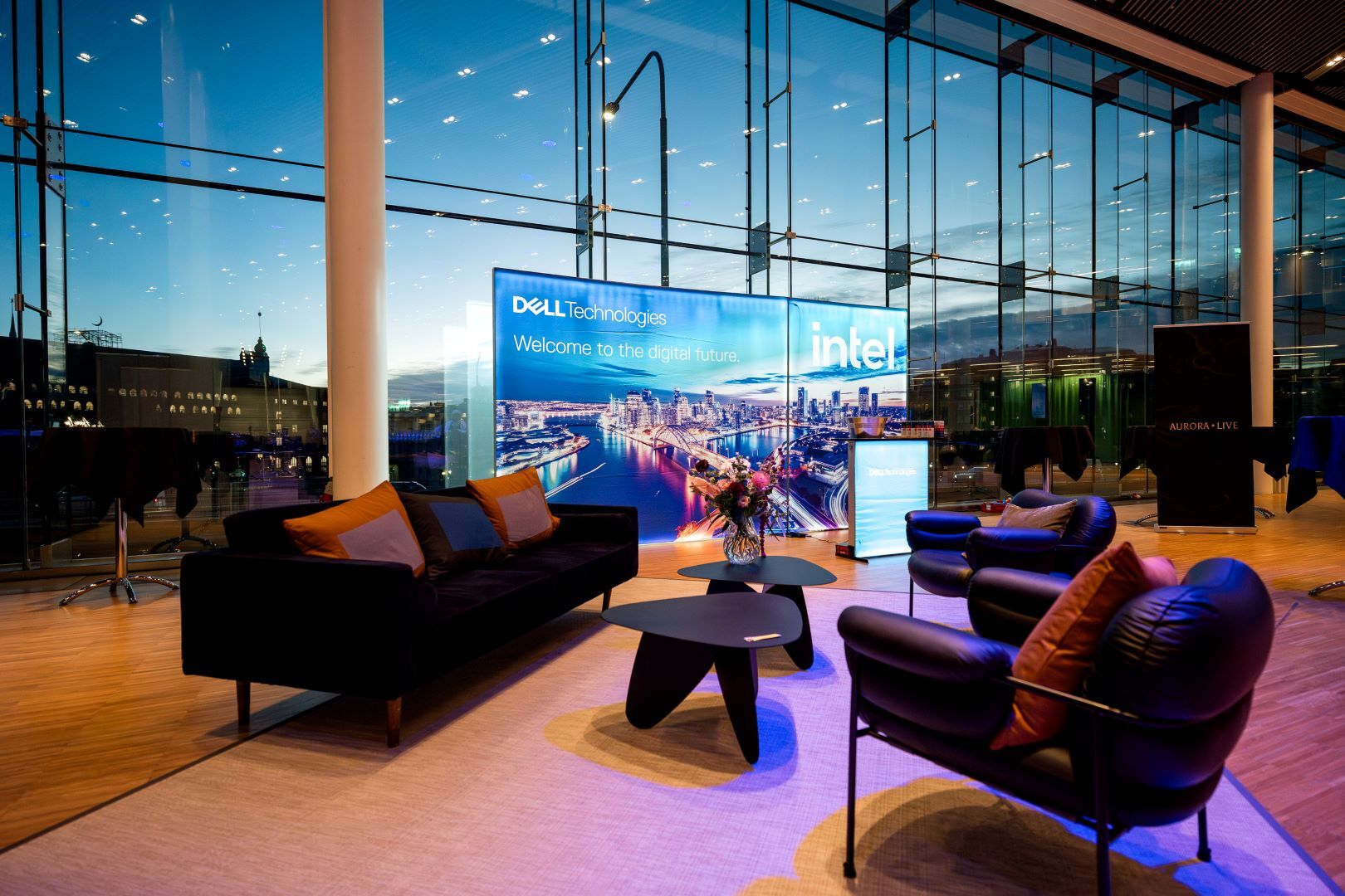 Branded lounge with seats and a large logo screen in the background