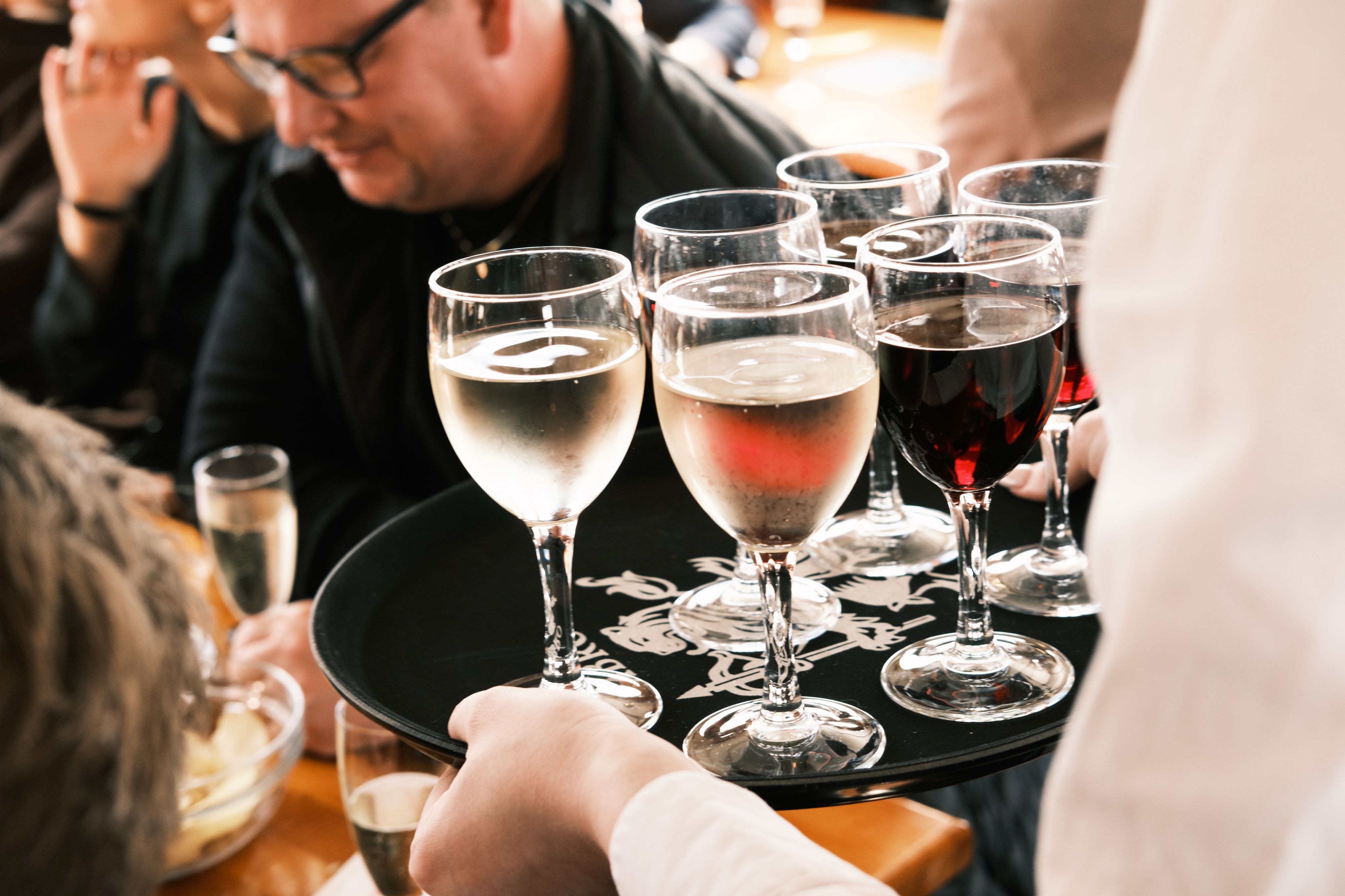 Serveur tenant un plateau de verres de vin lors d’un événement de réseautage professionnel